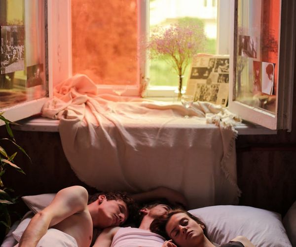 Person peacefully stretching by a window at sunrise.
